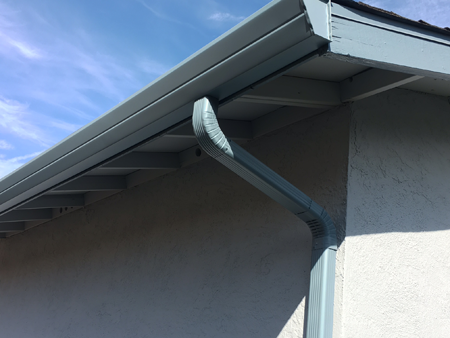 House with new rain gutter and downspout installed.