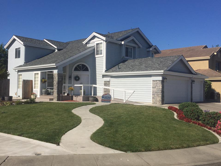 Two story house with new roof of composition tiles installed. 